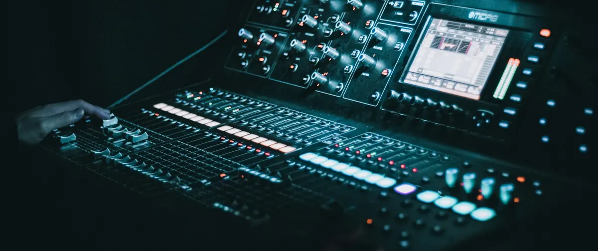 Mesa de mezclas de un control de sonido, con sus canales y medidores iluminados
